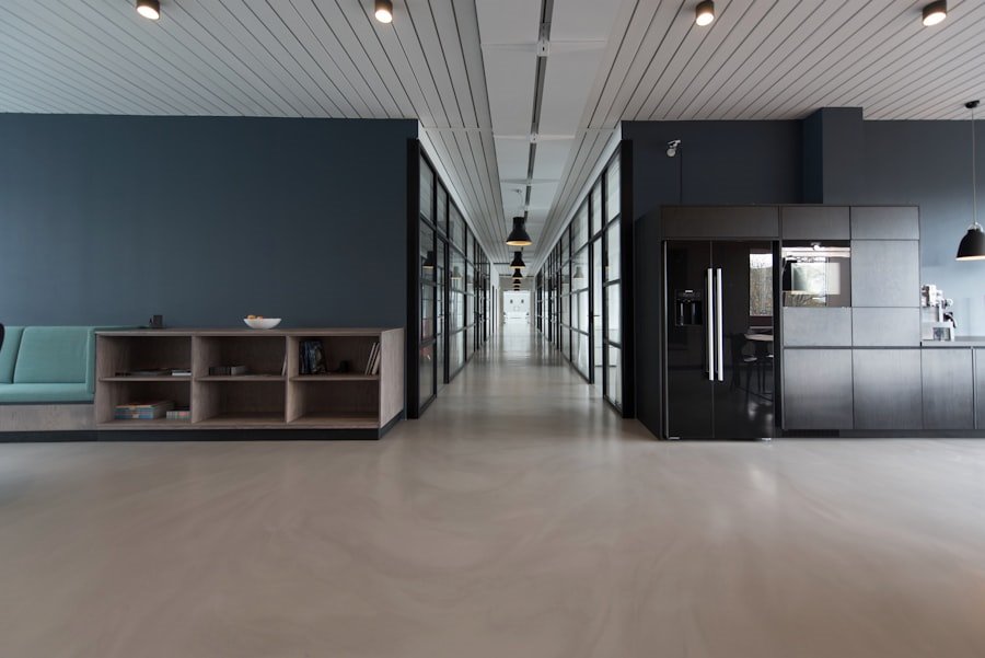 Long polished-concrete corridor through a dark-panelled workplace